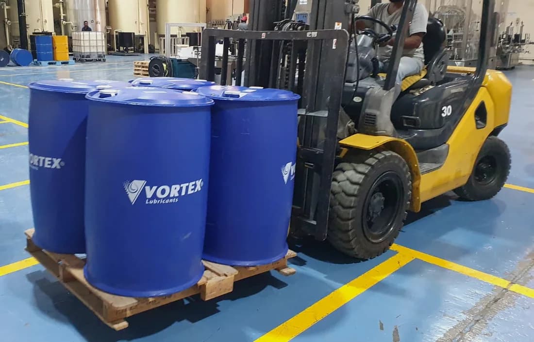 Blue Vortex drums on a pallet with a forklift alongside