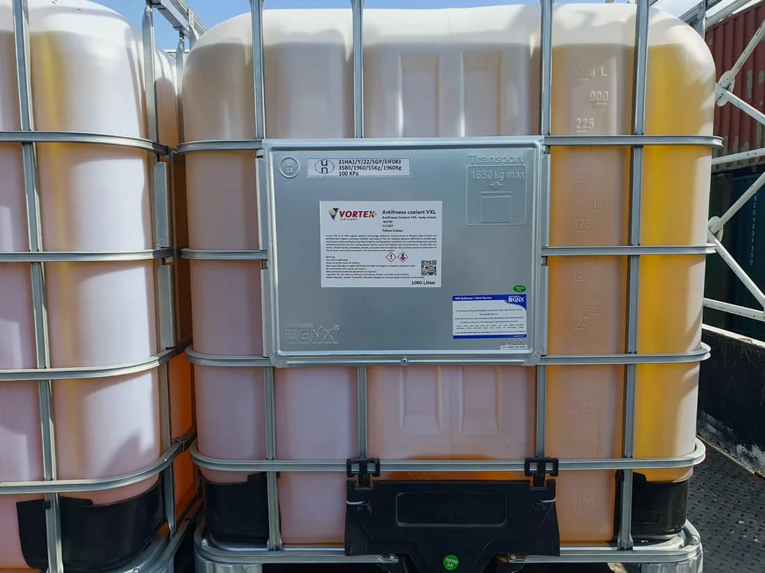 Intermediate bulk container with a Vortex label, filled with amber fluid